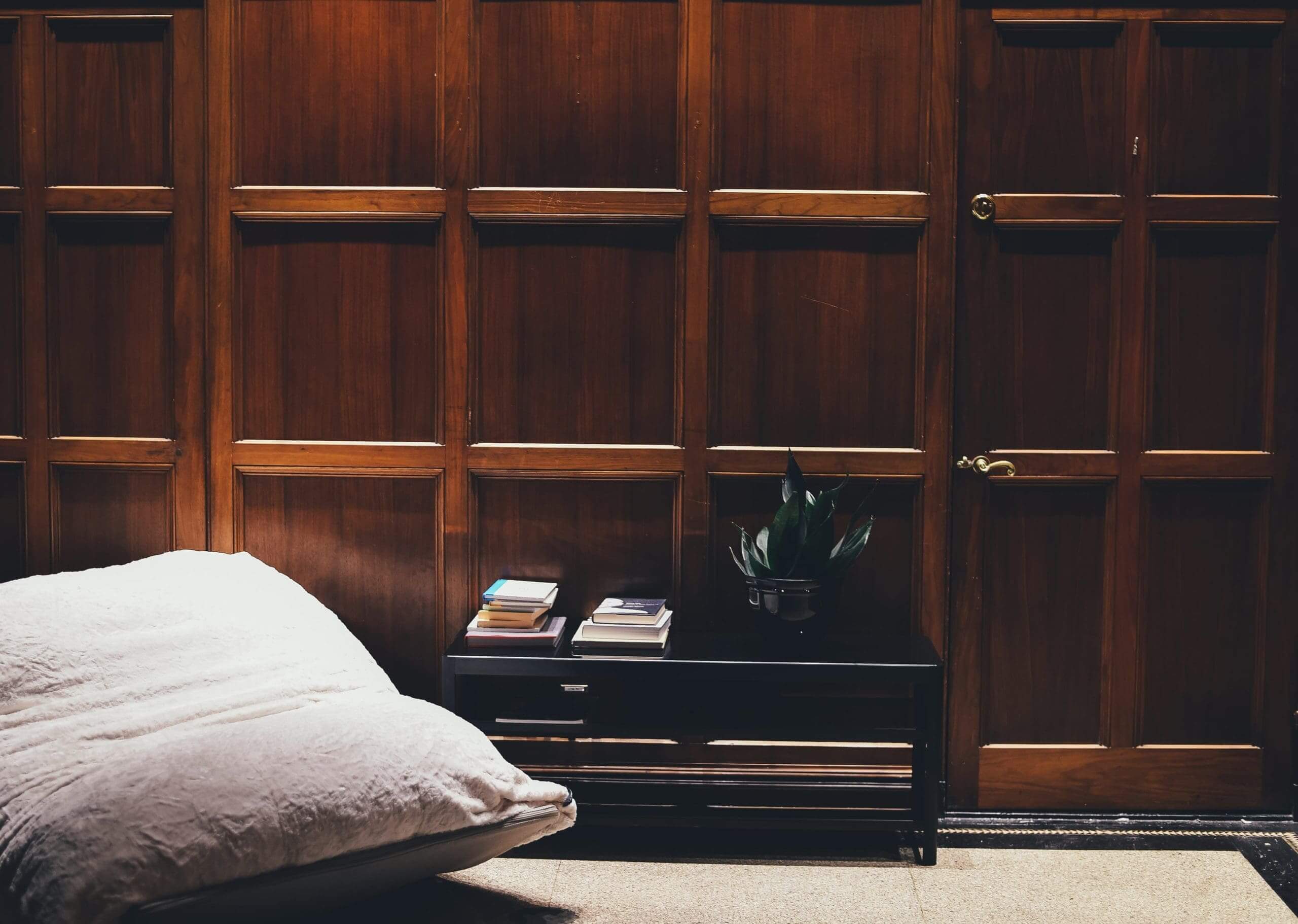 Coffee table and a pillow chair next to a wall with wooden panelling